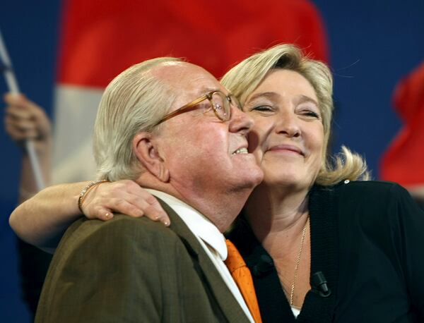 FILE- Honorary President of far-right party National Front Jean-Marie Le Pen, left, and his daughter French far-right leader and National Front Party candidate for the 2012 French presidential elections, Marine Le Pen, during a campaign meeting in Marseille, southern France, Sunday, March 4, 2012. (AP Photo/Claude Paris, File)