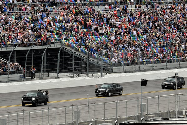 President Donald Trump, center, in the presidential limousine known as "The Beast" does a lap around the track at the NASCAR Daytona 500 auto race at Daytona International Speedway, Sunday, Feb. 16, 2025, in Daytona Beach, Fla. (Pool via AP)