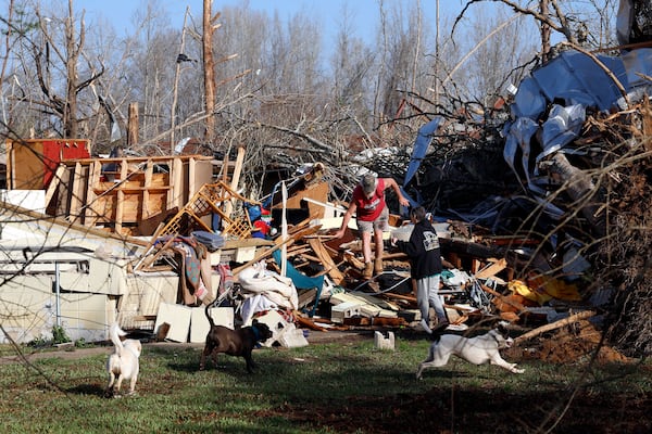 Emily and Tony Robertson look for personal belongings in the damage after a tornado passed through, Sunday, March 16, 2025, in Plantersville, Ala. (AP Photo/Butch Dill)