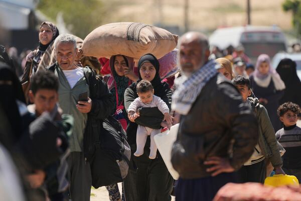 Displaced Palestinians, who flee from Rafah amidst ongoing Israeli military operations following Israel's renewed offensive in the Gaza Strip, arrive in Khan Younis, Gaza, on Sunday, March 23, 2025. (AP Photo/Abdel Kareem Hana)