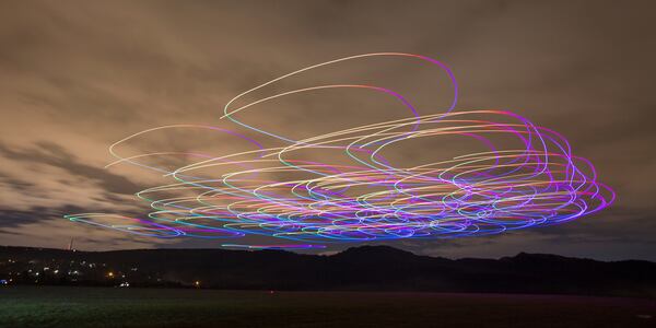 This handout photo long exposure shot shows the flight of a flock of autonomous drones during an experiment near Budapest, Hungary, Thursday, Oct. 21, 2021. (AP Photo/HO/Eotvos Lorand University)