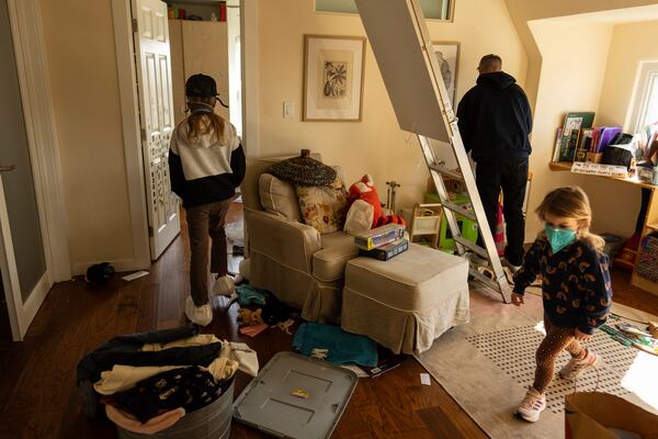 Eaton Fire evacuee Craig Phillips visits his home with his two children, Ceiba, left, and Quoia, in Altadena, Calif., Saturday, Feb. 8, 2025. Although the family's in-law suite was gutted, the Phillips' home was one of the few in their neighborhood that survived the fire. (AP Photo/Jae C. Hong)