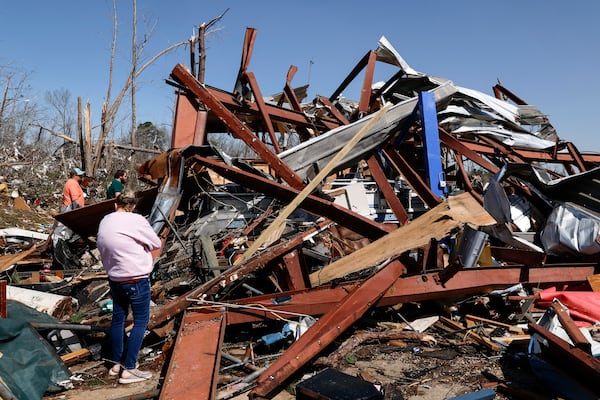 Friends and family members search for belongings in the damage after a tornado passed through the area, Sunday, March 16, 2025, in Plantersville, Ala. (AP Photo/Butch Dill)