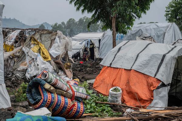 A woman and her child displaced by the fighting between M23 rebels and government soldiers prepare to leave the camp following an instruction by M23 rebels in Goma, Democratic Republic of the Congo, Tuesday, Feb. 11, 2025. (AP Photo/Moses Sawasawa)