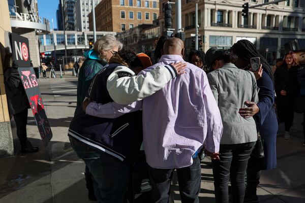 A group of community advocates and Black Lives Matter members pray before a news conference outside Target Corporation's headquarters Thursday, Jan. 30, 2025, in Minneapolis, Minn. (AP Photo/Ellen Schmidt)