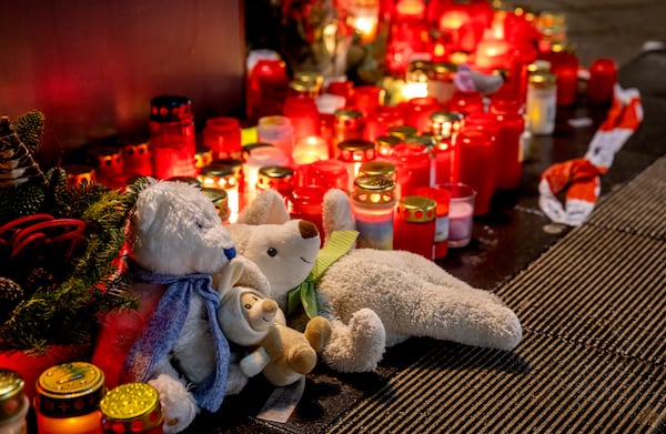 Teddy bears were laid together with candles near the Christmas market, where a car drove into a crowd on Friday evening, in Magdeburg, Germany, Sunday, Dec. 22, 2024. (AP Photo/Michael Probst)