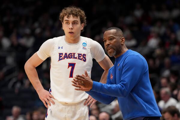 American University's Wyatt Nausadis (7) speaks with head coach Duane Simpkins during the first half of a First Four college basketball game against Mount St. Mary's in the NCAA Tournament, Tuesday, March 19, 2025, in Dayton, Ohio. (AP Photo/Jeff Dean)