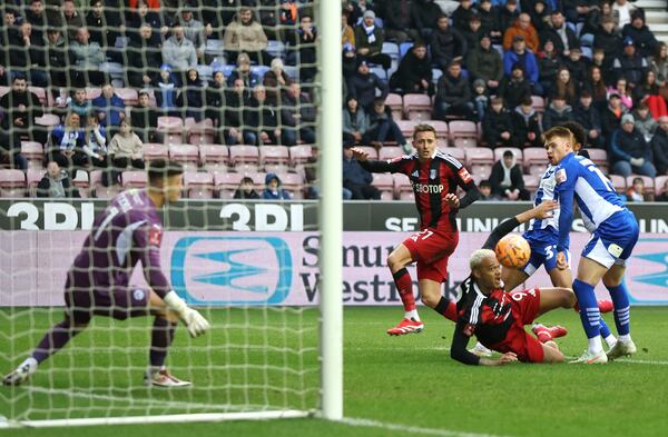 Wigan Athletic's Luke Robinson, right, scores an own goal during the Englsih FA Cup fourth round soccer match between Wigan Athletic and Fulham at The Brick Community Stadium, Wigan, England, Saturday Feb. 8, 2025. (Barrington Coombs/PA via AP)