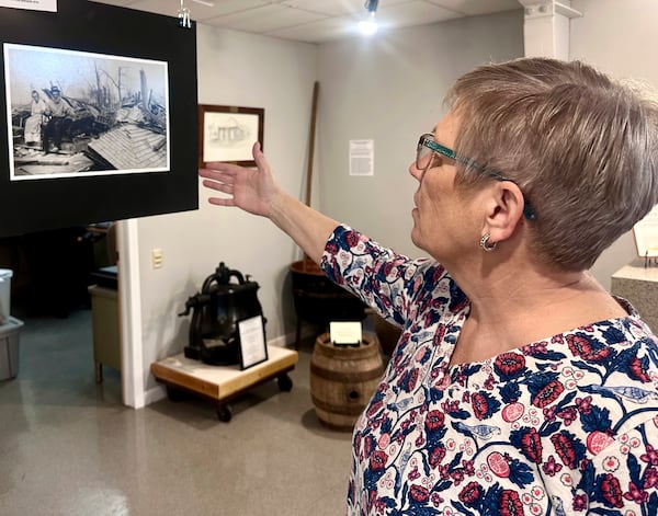 Jackson County Historical Society President Laura Cates Duncan describes a photo on display at the society's office of an elderly couple sitting on the ruins of their home after the March 18, 1925 Tri-State Tornado on March 11, 2025 in Murphysboro, Ill. (AP Photo/John O'Connor)