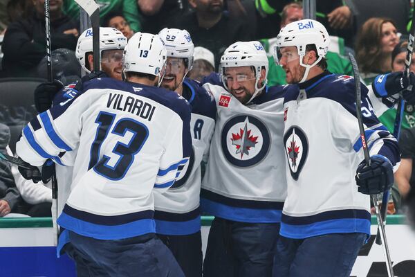 Winnipeg Jets' Gabriel Vilardi (13), Kyle Connor, left rear, Mark Scheifele, center rear, Neal Pionk (4) and Dylan Samberg, right, celebrate after Scheifele scored against the Dallas Stars in the second period of Game 6 of a second-round NHL hockey playoff series in Dallas, Saturday, May 17, 2025. (AP Photo/Gareth Patterson)