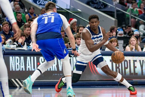 Minnesota Timberwolves guard Anthony Edwards (5) makes a move on Dallas Mavericks guard Luka Doncic (77) in the first half of an NBA basketball game on Wednesday, Dec. 25, 2024, in Dallas.(AP Photo/Emil T. Lippe)