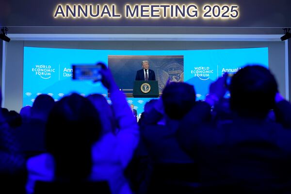 People follow a virtual speech of U.S. president Donald Trump at the Annual Meeting of World Economic Forum in Davos, Switzerland, Thursday, Jan. 23, 2025. (AP Photo/Markus Schreiber)