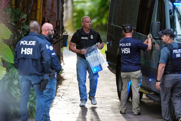 FILE - A law enforcement agent carries a bag of evidence to a van as federal agents stand at the entrance to a property belonging to rapper Sean "Diddy" Combs, on March 25, 2024, on Star Island in Miami Beach, Fla. (AP Photo/Rebecca Blackwell, File)