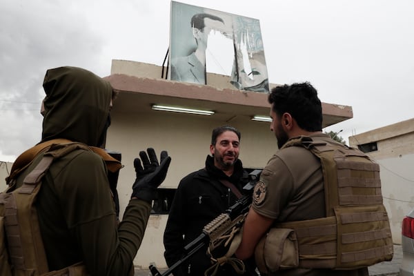 A member of Bashar Assad's army, or a pro-government militia, talks to members of the security forces of the newly formed Syrian government as he takes part in an "identification and reconciliation" process in Damascus, Syria, Monday, Dec. 30, 2024. (AP Photo/Omar Sanadiki)