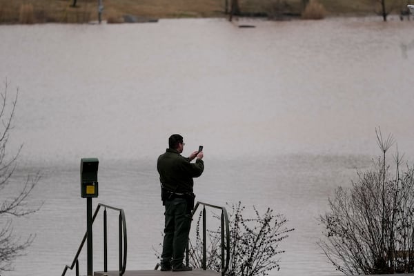 A park ranger takes picture of flood water at Dunbar Cave State Park, Sunday, Feb. 16, 2025, in Clarksville, Tenn. (AP Photo/George Walker IV)