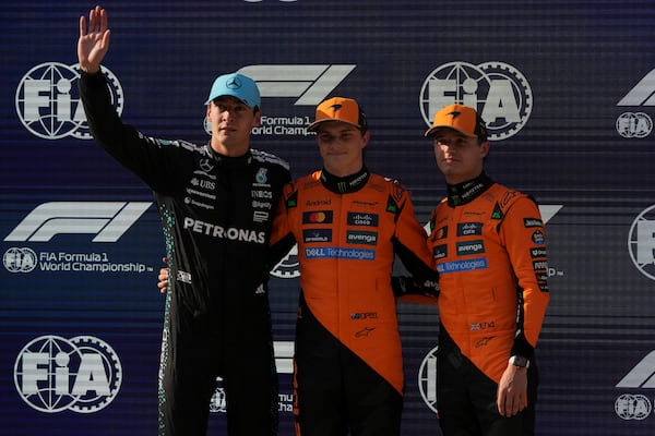 McLaren driver Oscar Piastri of Australia is flanked with Mercedes driver George Russell of Britain, left, and McLaren driver Lando Norris of Britain, right, after qualifying session for the Chinese Formula One Grand Prix at the Shanghai International Circuit, Shanghai, Saturday, March 22, 2025. (AP Photo/Andy Wong)