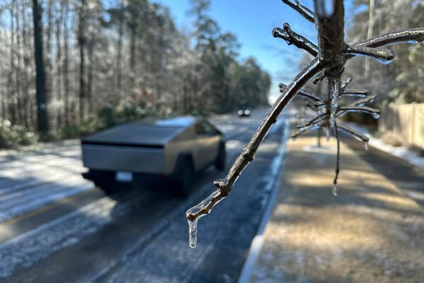 A Tesla Cybertruck passes an ice-encased tree along a slick road in Wake Forest, N.C,. Saturday, Jan. 11, 2025. (AP Photo/Allen G. Breed)