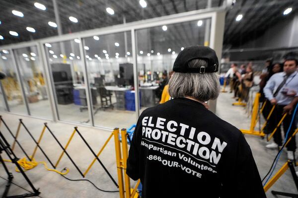 FILE - A non-partisan election volunteer observes as memory cards are uploaded from early voting at the Fulton County Election Hub and Operation Center, Nov. 5, 2024, in Atlanta, Mo. (AP Photo/John Bazemore, File)