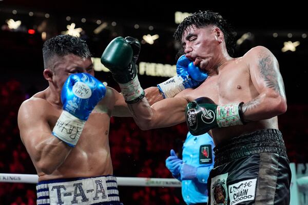 Isaac Cruz, left, hits Angel Fierro in a super lightweight boxing match Saturday, Feb. 1, 2025, in Las Vegas. (AP Photo/John Locher)