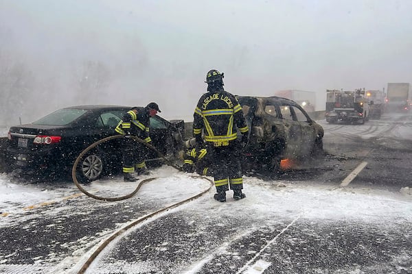 In this image provided by the Multnomah County Sheriff's Office officials respond after a vehicle caught fire on westbound Interstate 84 on Thursday, Feb. 13, 2025, near Multnomah Falls, Ore. (Multnomah County Sheriff's Office via AP)