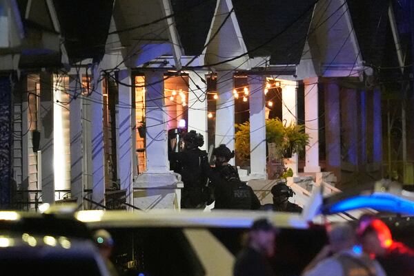 Louisiana state police enter a house on North Galvez street as they pursue a fugitive that escaped from a New Orleans jail, Tuesday, May 20, 2025, in New Orleans. (AP Photo/Gerald Herbert)