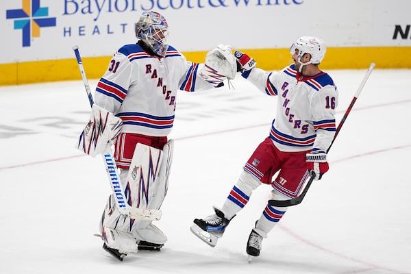 New York Rangers' Igor Shesterkin (31) and Vincent Trocheck (16) celebrate the team's win in an NHL hockey game against the Dallas Stars in Dallas, Friday, Dec. 20, 2024. (AP Photo/Tony Gutierrez)