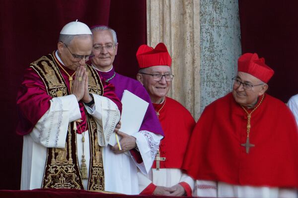 Newly elected Pope Leo XIV, left, formerly Cardinal Robert Francis Prevost, appears with, from left, Master of Ceremonies Archbishop Diego Giovanni Ravelli, Cardinal Pietro Parolin, and Cardinal Vinko Puljić on the central loggia of St. Peter's Basilica at the Vatican shortly after his election as the 267th pontiff of the Roman Catholic Church, Thursday, May 8, 2025. (AP Photo/Domenico Stinellis)