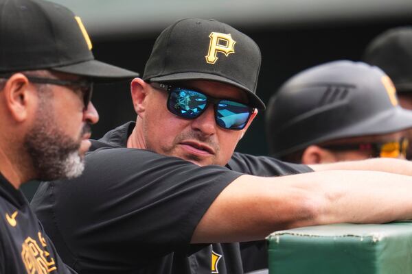 Pittsburgh Pirates bench coach Don Kelly, center, stands in the dugout with pitching coach Oscar Marin during a baseball game against the Chicago Cubs in Pittsburgh, Thursday, May 1, 2025. (AP Photo/Gene J. Puskar)