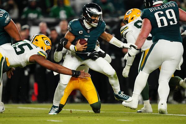 Philadelphia Eagles quarterback Jalen Hurts (1) is sacked by Green Bay Packers defensive end Rashan Gary (52) as Green Bay Packers defensive end Kingsley Enagbare (55) narrows in during the second half of an NFL wild-card playoff football game Sunday, Jan. 12, 2025, in Philadelphia. (AP Photo/Derik Hamilton)