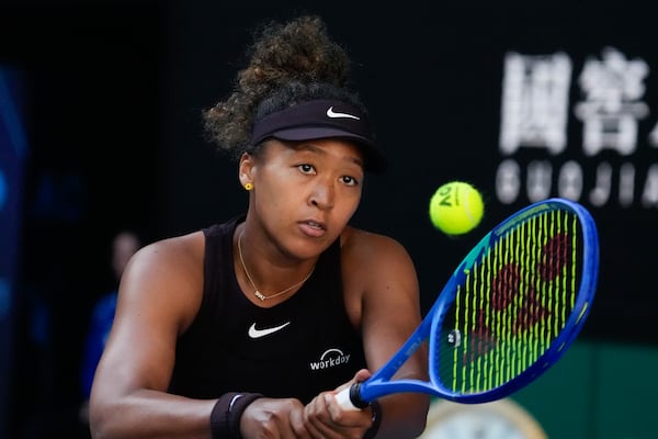 Naomi Osaka of Japan plays a backhand return to Belinda Bencic of Switzerland during their third round match at the Australian Open tennis championship in Melbourne, Australia, Friday, Jan. 17, 2025. (AP Photo/Manish Swarup)